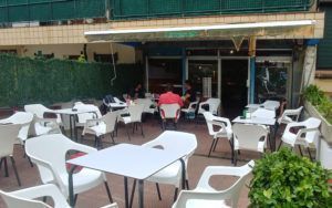 Exterior space of the bar Tsunami with tables and chairs