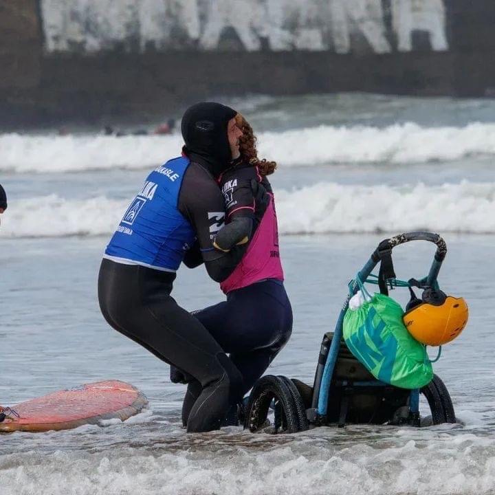 Moniteur aidant les personnes à mobilité réduite à monter sur une planche de surf